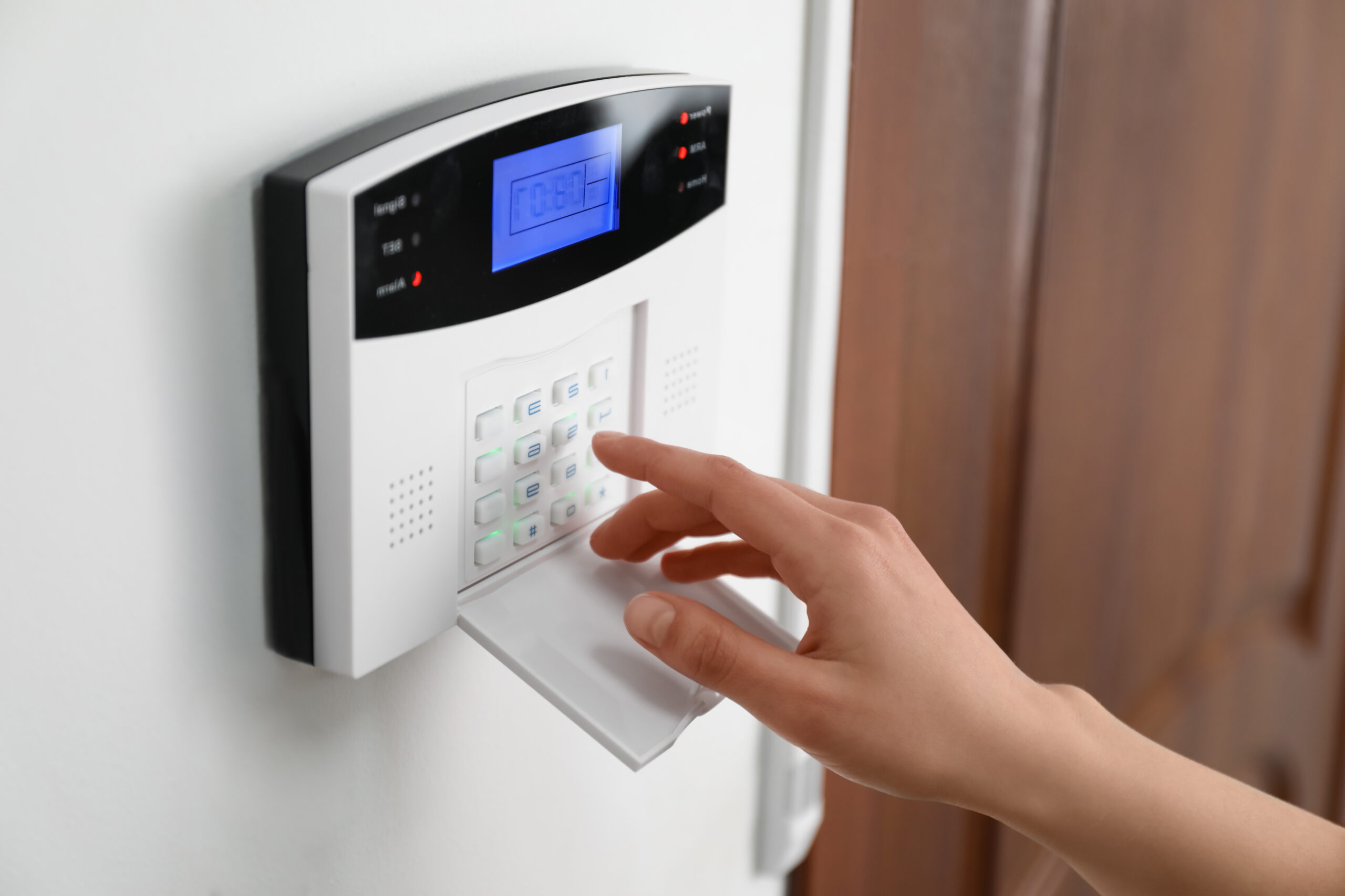 Woman,Entering,Code,On,Home,Security,System,Near,Door,,Closeup alarm system