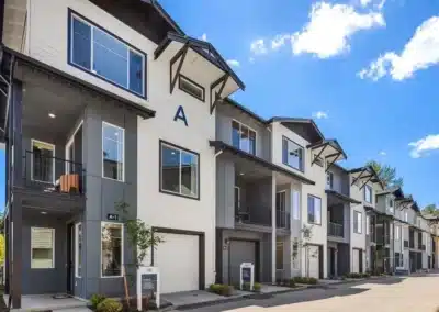 Three-storey walk-up apartment building with gabled dormers and lap siding
