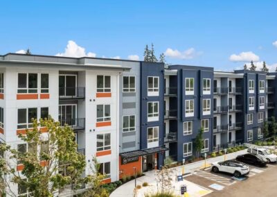 Five-storey multi-family apartment building with white, navy and orange fiber cement cladding