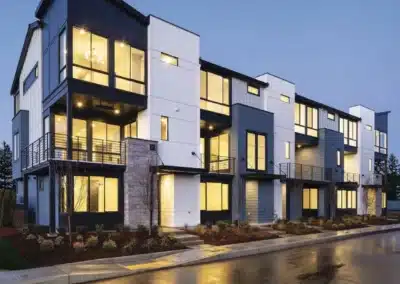 Modern townhomes at twilight with stone accent siding