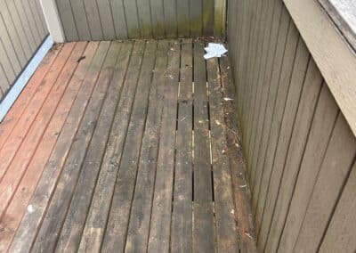Worn timber decking on a balcony at Phoenix Court Apartments, Kent WA, before renovation.