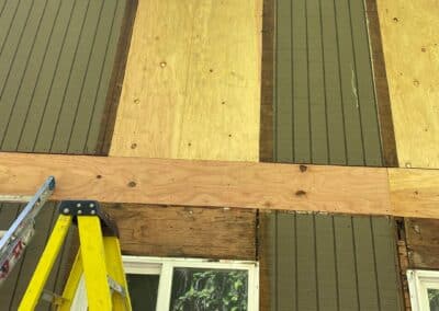 Old cladding removed at Phoenix Court Apartments, exposing sheathing and framing.